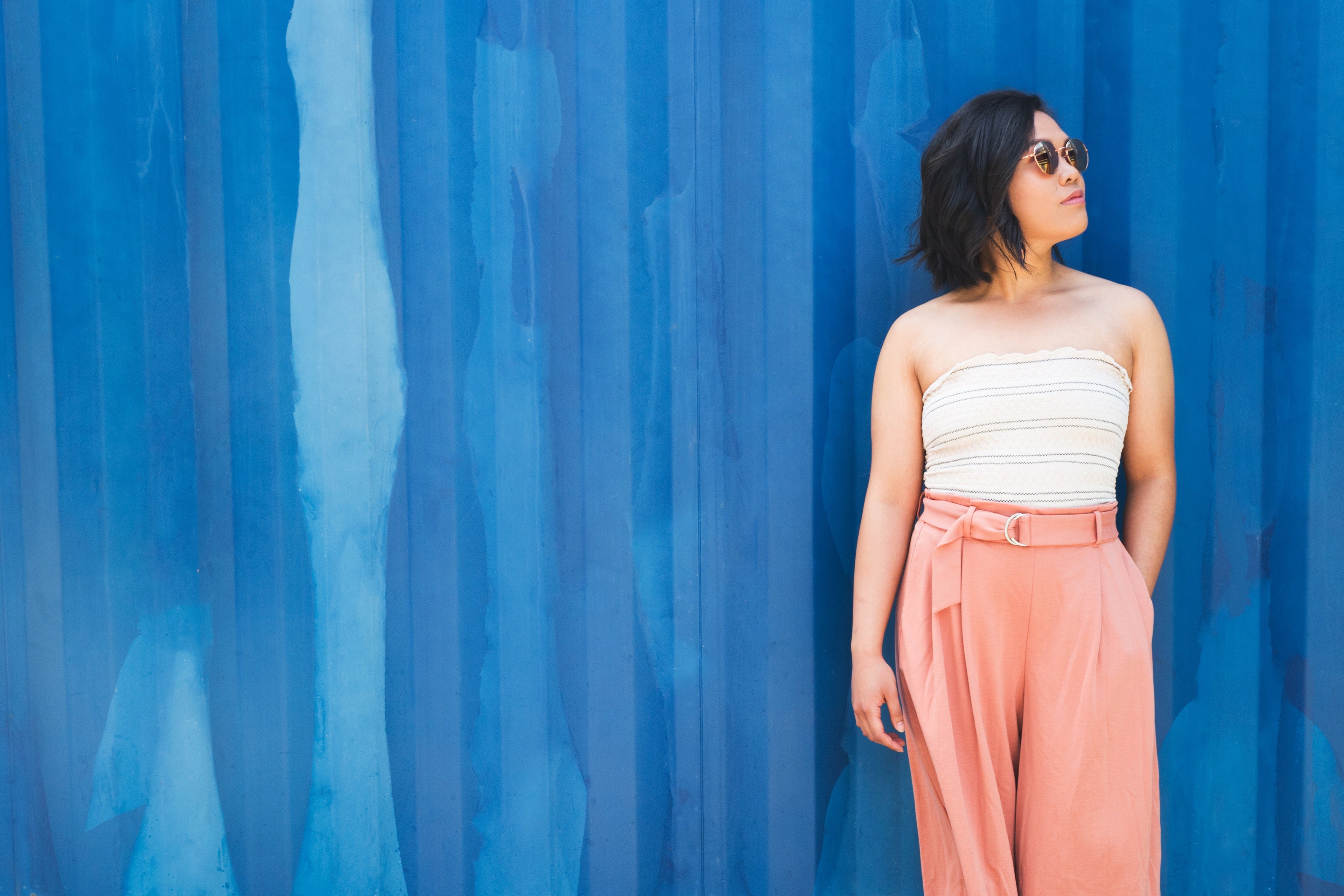 Ragazza in piedi su un muro azzurro