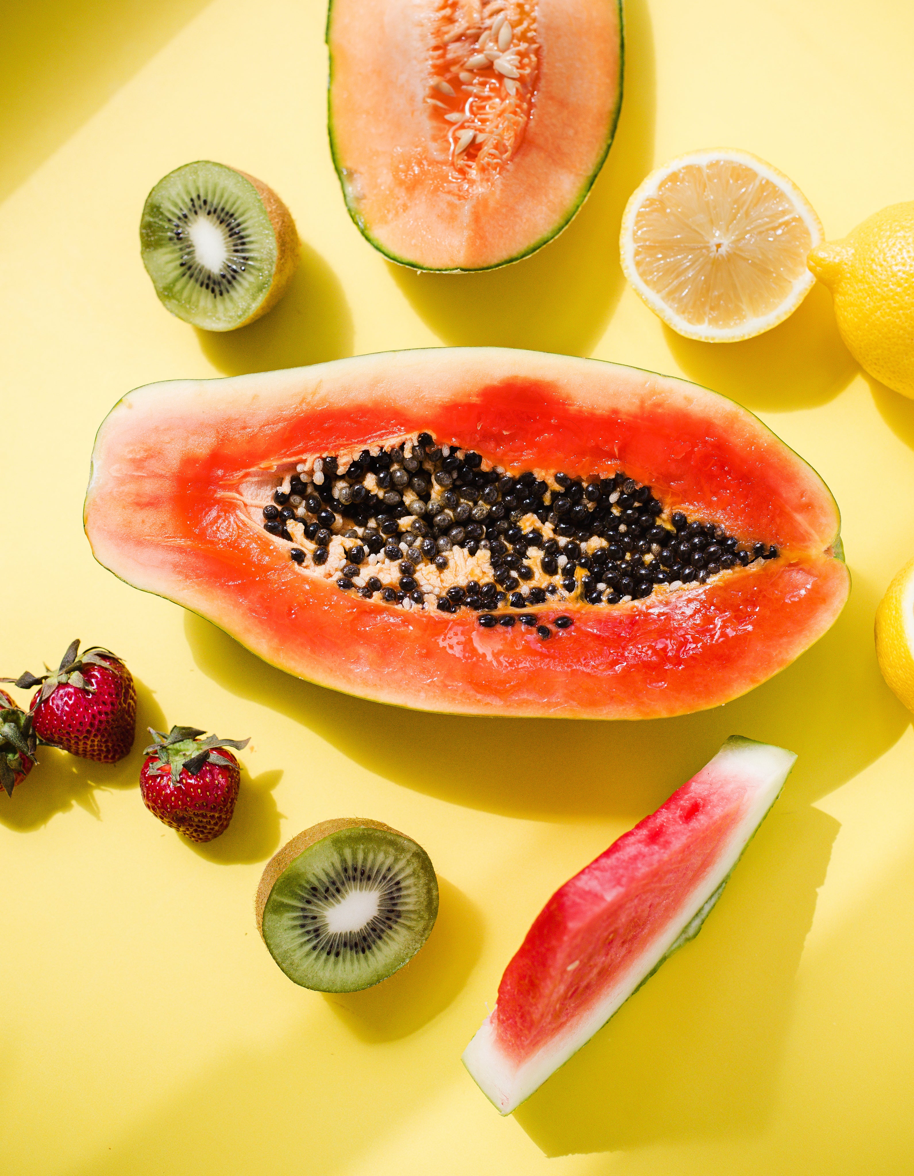 Papaya e altri frutti su sfondo giallo